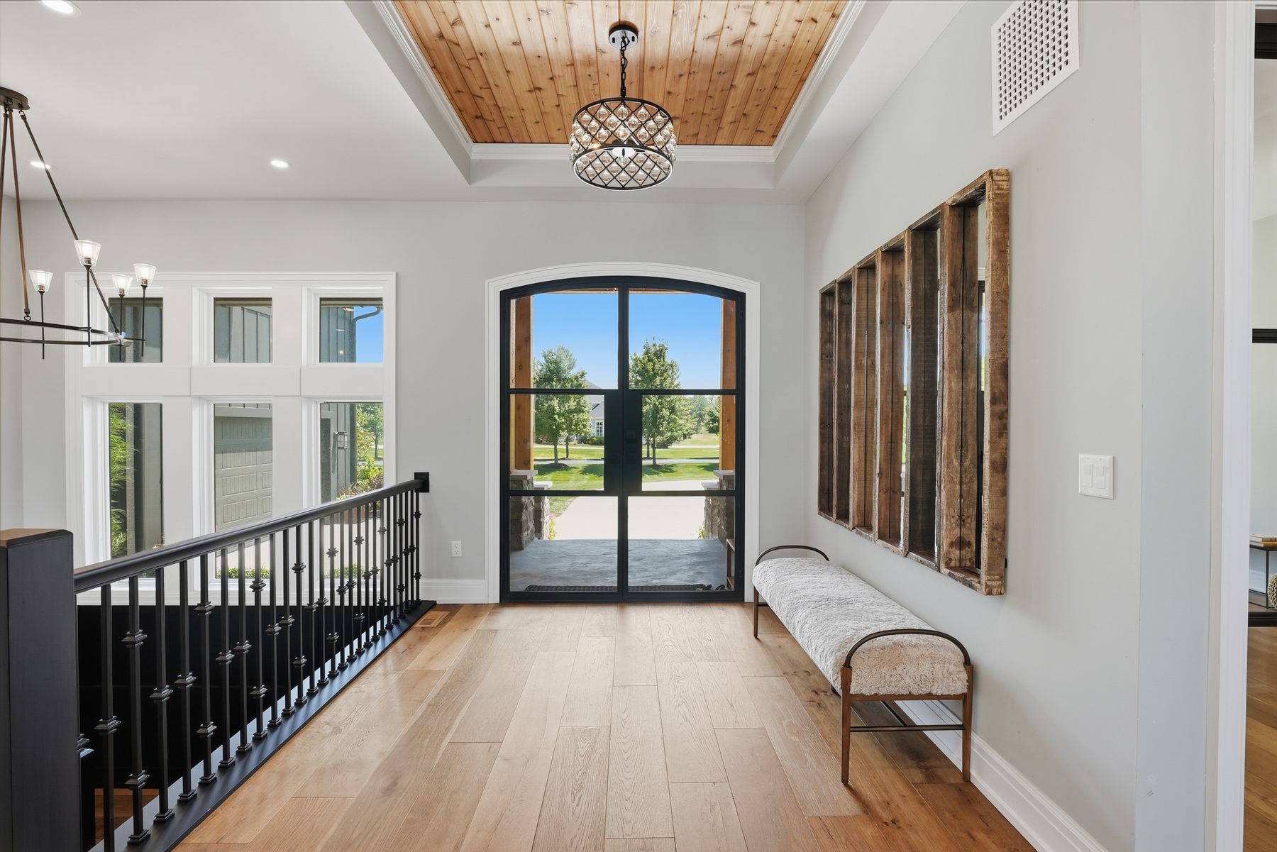 Foyer with arched steel doors and wood ceiling